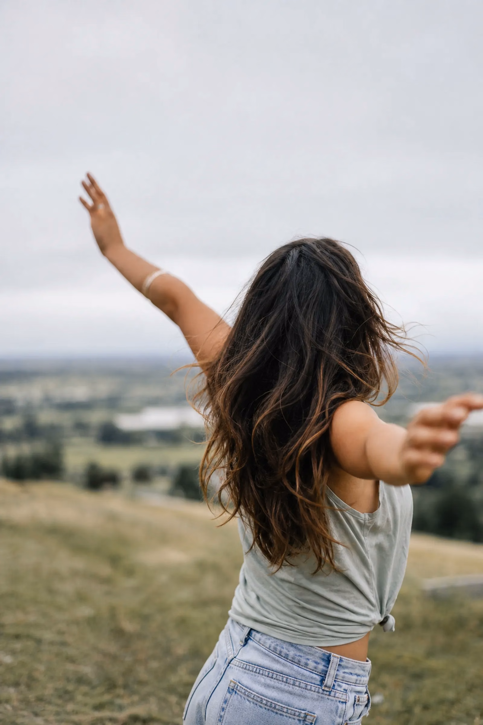 Person with arms raised enjoying an outdoor view
